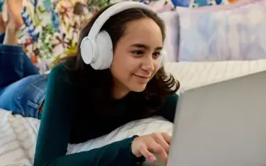 Student wearing a white pair of headphones