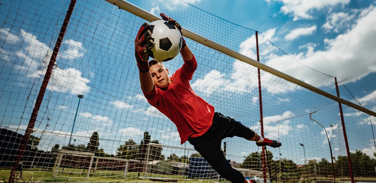 Student playing soccer wearing a red shirt